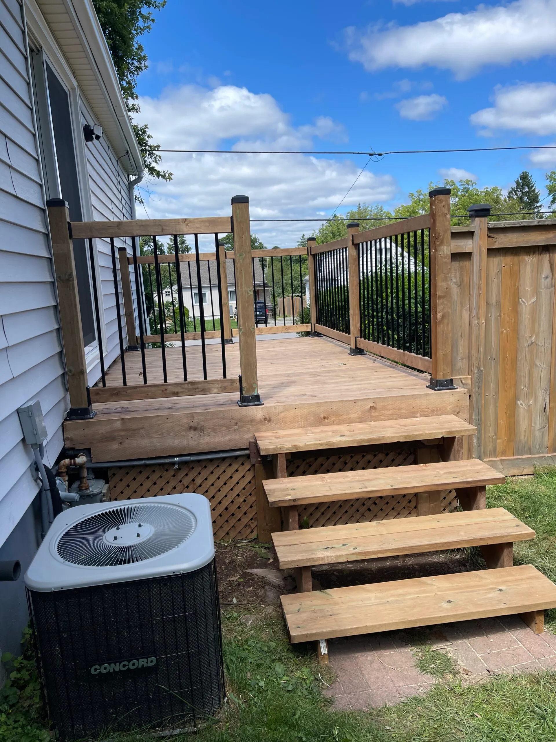 New pressure-treated backyard deck with aluminum railings